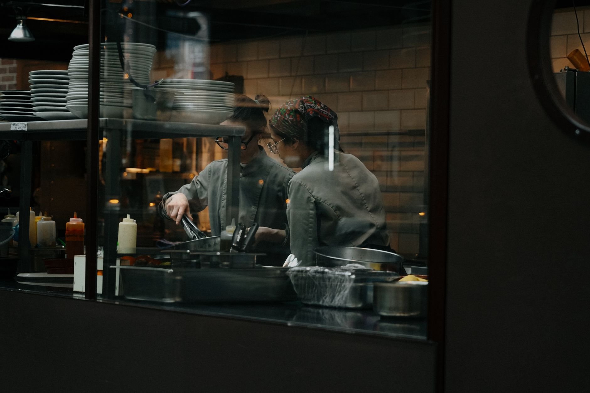 Candid shot of chefs cooking in a restaurant kitchen.